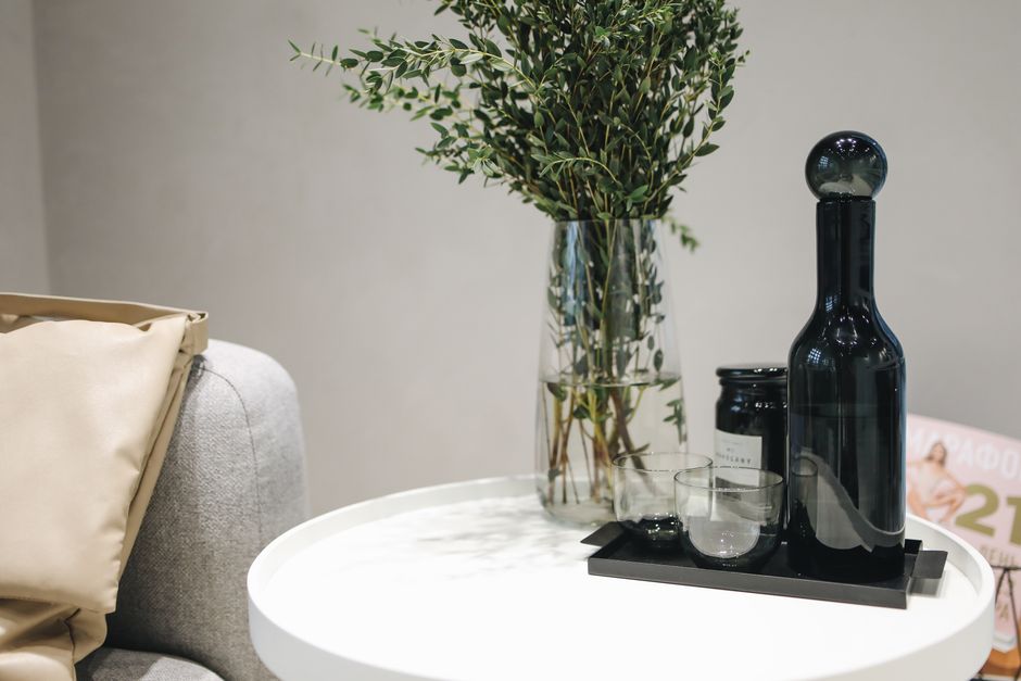Chic interior showcasing stylish decor with a vase and glass bottle on a round table.